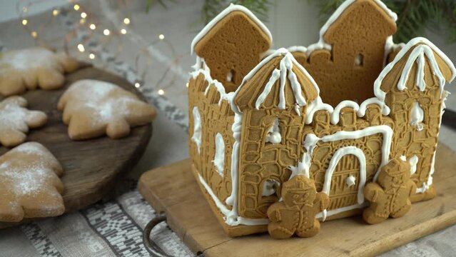 Gingerbread house Christmas homemade baking. Gingerbread Man. astle with white icing. Cookies in the shape of a Christmas tree and snowflakes on the table. Food for dessert. Winter gingerbread.
