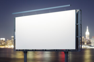 Blank white billboard on cityscape background at evening, perspective view. Mock up, advertising concept