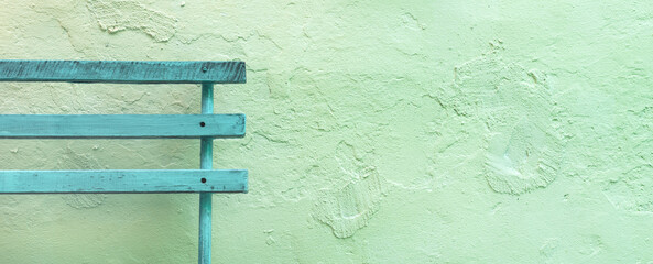 Old wooden bench on timeworn wall surface as copy space and background