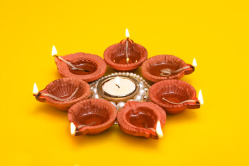 Concept of indian festival diwali. Traditional oil lamps on yellow background.