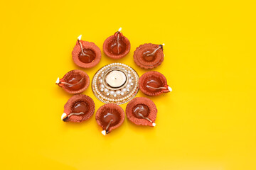 Concept of indian festival diwali. Traditional oil lamps on yellow background.