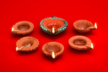 Obraz na płótnie Canvas Concept of indian festival diwali. Traditional oil lamps on Red background.