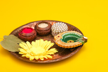 Indian festival diwali concept. Traditional puja thali on yellow background.