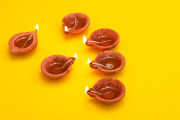 Concept of indian festival diwali. Traditional oil lamps on yellow background.