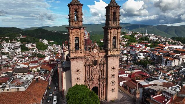 Aerial view in front of the Church of Santa Prisca de Taxco, in sunny Mexico - ascending, drone shot