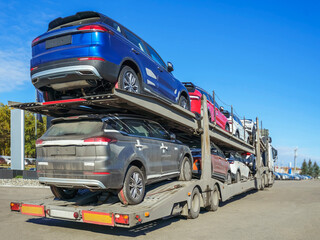 Transporter is waiting to unload the vehicles. New cars are coming