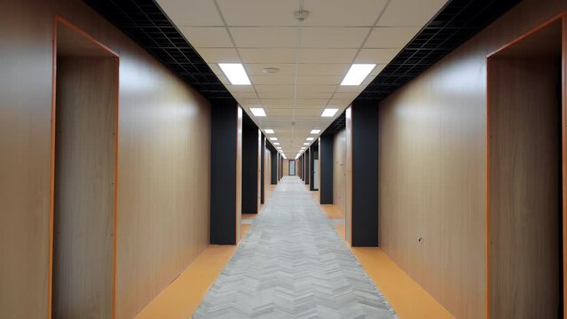 A long office corridor without people. A person's view of moving down a corridor POV.