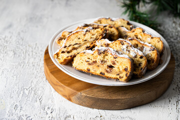 Close up of Stollen fruit bread slices with dried fruit and marzipan coated with powdered icing sugar.