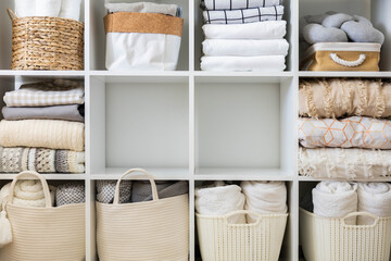 Fototapeta na wymiar Bed linens closet neatly arrangement on shelves with copy space domestic textile Nordic minimalism