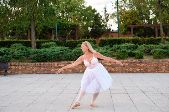 Mature Woman Dancing Ballet In A Park At Street.