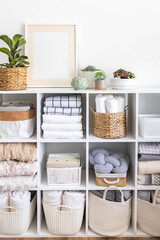 Minimalism Nordic closet shelves neatly folded bed linens and potted plants frame border copy space