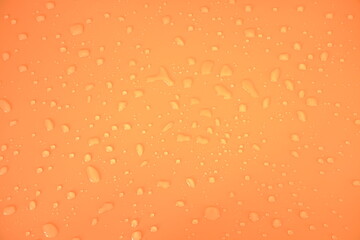 Defocus blurred water drops on orange background. waterdrops detail the background. Water splash, water spray background. Calm orange background with water drop.