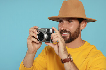 Man with camera on light blue background. Interesting hobby