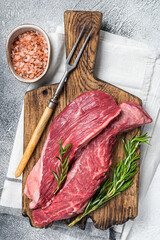 Butcher choise Bavette raw beef meat steak or skirt flap on a wooden board with herbs. White...