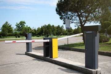 Modern road barriers and parking meter outdoors on sunny day