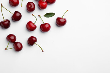 Many sweet ripe cherries on white background, flat lay. Space for text