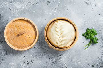 Pyanse steamed bun in a Bamboo steamer, korean street food. Gray background. Top view