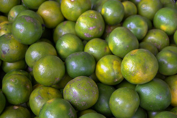 Close up of fresh green orange. Bunch of green lemon at market