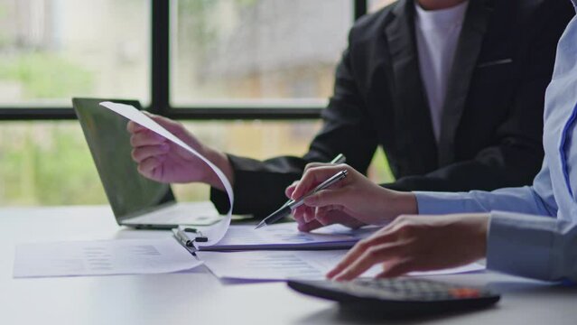Close up of hands business teamwork are working and brainstorming calculate on paperworks about business financial and marketing that shows chart and graft of accounting statistics, number of cost.