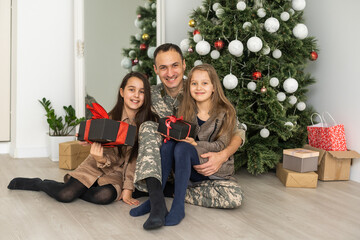 Obraz na płótnie Canvas military father and children near christmas tree