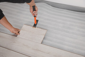 Worker installing new laminate flooring in room, closeup