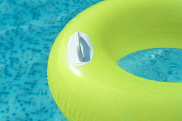 Light green inflatable ring floating in swimming pool, closeup