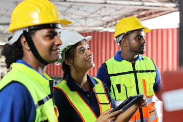 Group of warehouse workers with hardhats and reflective jackets standing and raising hands celebrate successful together or completed deal commitment at retail warehouse logistics, distribution center