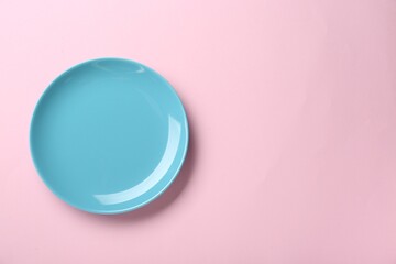 Clean light blue plate on pink background, top view. Space for text