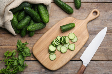 Fresh ripe cucumbers and parsley on wooden table, flat lay