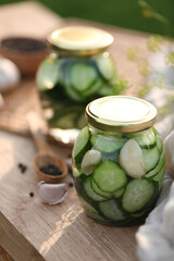 Jar of delicious pickled cucumbers on wooden table, closeup