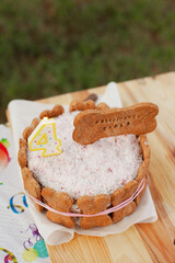 Cake closeup at birthday party for a dog. Dog bakery small business. Puppy cake with a bone cookie treat and a candle.