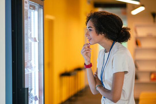 Young Woman Choosing Something From The Fridge In The Office Canteen