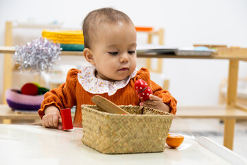 Toddler playing with wooden fruit toys