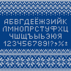Cyrillic font in sweater style. Knitted russian letters, numbers and symbols for New Year holidays and winter season. Alphabet and scandinavian patterns on blue knit background. Typeface vector design