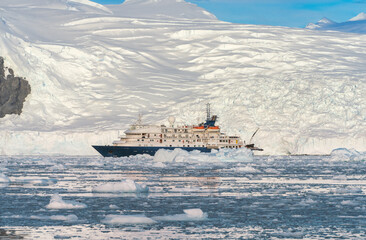 blaues Expeditionsschiff vor antarktischer Eisberg Landschaft in der Cierva Cove - ein tiefer...