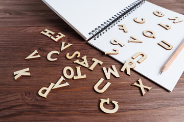 Spiral notebook and wooden letters on the table