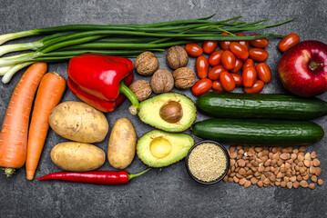 Healthy food background. Healthy vegetarian food. Vegetables and fruits on black stone. Clean vegetarian eating concept.