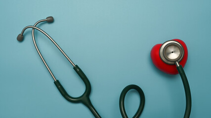 Stethoscope and red heart on blue background. Healthcare, cardiology and life insurance concept
