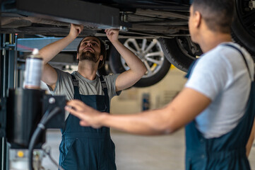 Auto repair service staff inspecting the client vehicle