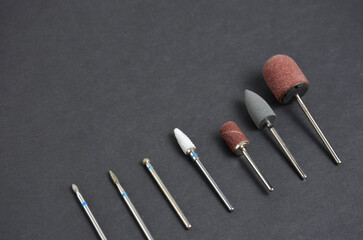 A set of nozzles for a manicure machine. Grey background.