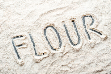 Background with flour. Text made of fresh spelt flour, texture.