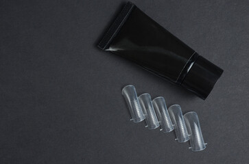 Tips and gel for nail extension. Black background.