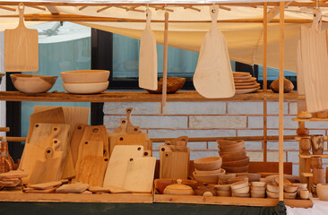 Stand at a street market selling wooden kitchen accessories as bowls, dishes and cutting boards
