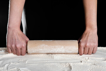 Baker hands with rolling pin on flour. Baking bread concept.