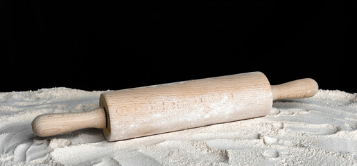 Baking background with rolling pin and flour on table.