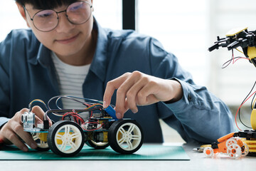 Technology of robotics programing and STEM education concept. Science, Technology, Engineering and Mathematics education. Asian teenager doing robot project in science classroom.