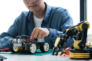 Technology of robotics programing and STEM education concept. Science, Technology, Engineering and Mathematics education. Asian teenager doing robot project in science classroom.