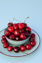 Top view of red sweet cherry on blue plate close up. Vegan, summer food concept. Diet