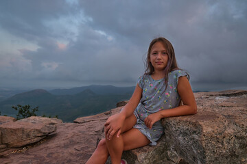 portrait of a girl against the sky and mountains