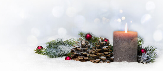 classical christmas decoration with burning candlelight in snowy winter idyll on blurred background, beautiful greeting concept card with copy space for december holiday season